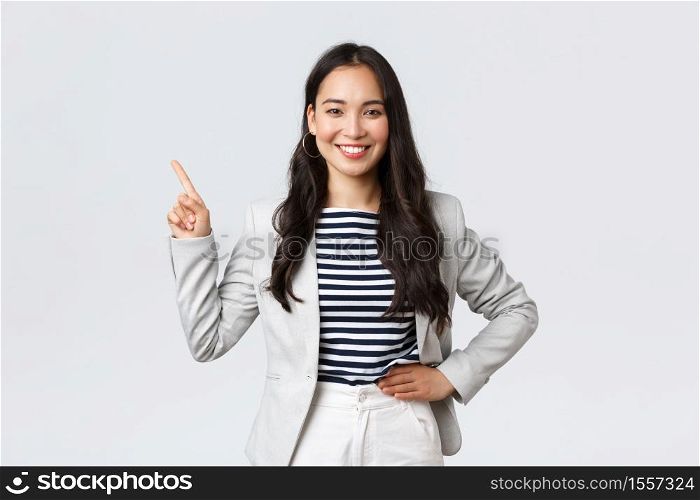 Business, finance and employment, female successful entrepreneurs concept. Cheerful successful businesswoman in white suit pointing fingers upper left corner, showing advertisement.. Business, finance and employment, female successful entrepreneurs concept. Cheerful successful businesswoman in white suit pointing fingers upper left corner, showing advertisement