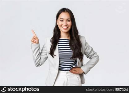 Business, finance and employment, female successful entrepreneurs concept. Cheerful successful businesswoman in white suit pointing fingers upper left corner, showing advertisement.. Business, finance and employment, female successful entrepreneurs concept. Cheerful successful businesswoman in white suit pointing fingers upper left corner, showing advertisement