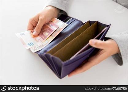 business, finance and payment concept - close up of woman hands with wallet and euro money. close up of woman hands with wallet and euro money