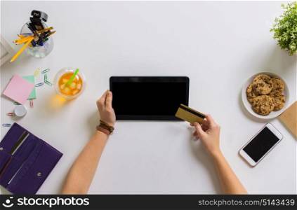 business, finance and technology concept - hands with tablet pc and credit card at table. hands with tablet pc and credit card at table