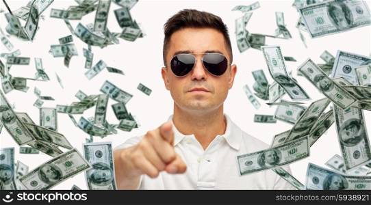 business, finance, gesture and people concept - face of middle aged latin man in sunglasses pointing finger on you with heap of falling dollar money