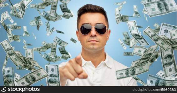 business, finance, gesture and people concept - face of middle aged latin man in sunglasses pointing finger on you over blue background with heap of falling dollar money