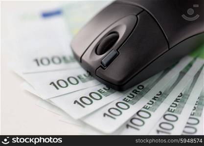 business, finance, internet earning and technology concept - close up of computer mouse and euro cash money on table