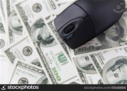 business, finance, internet earning and technology concept - close up of computer mouse and dollar cash money on table