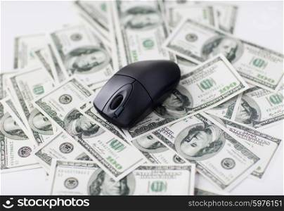 business, finance, internet earning and technology concept - close up of computer mouse and dollar cash money on table