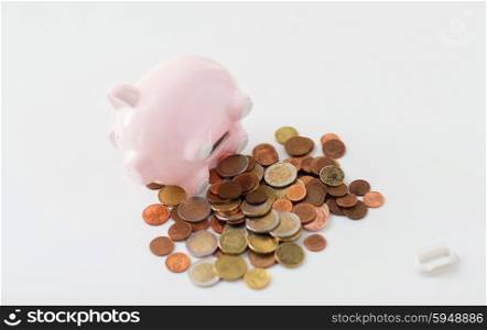 business, finance, investment, money saving and budget concept - close up of euro coins and piggy bank on table