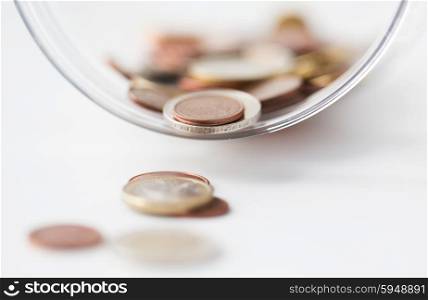 business, finance, investment, money saving and budget concept - close up of euro coins in glass jar on table