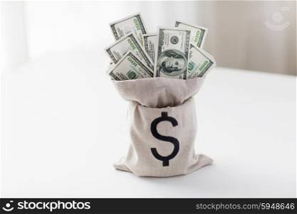business, finance, investment, saving and cash concept - close up of dollar paper money in bag on bank table