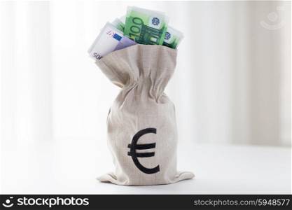 business, finance, investment, saving and cash concept - close up of euro paper money in bag on bank table
