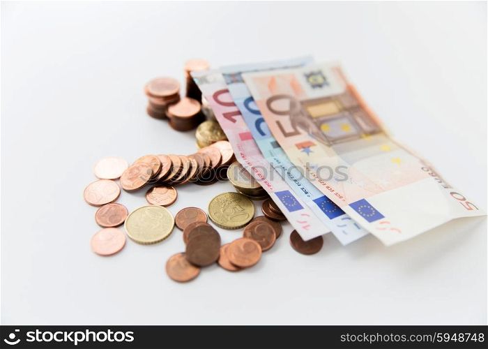 business, finance, investment, saving and cash concept - close up of euro paper money and coins on table