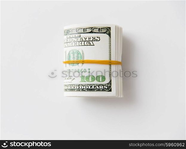business, finance, investment, saving and corruption concept - close up of dollar money packet tied with rubber on table