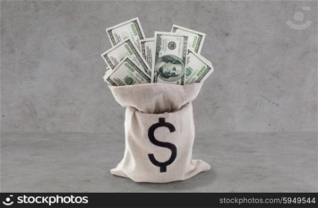 business, finance, investment, saving and currency concept - close up of dollar paper money in bag on bank table over gray concrete background
