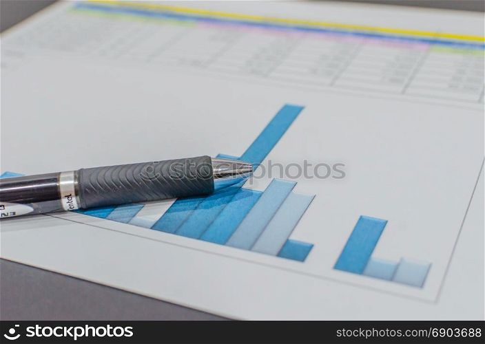 Business finance paper graphs analysis and pen.