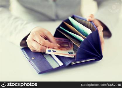business, finance, saving, banking and people concept - close up of woman hands with wallet and euro money