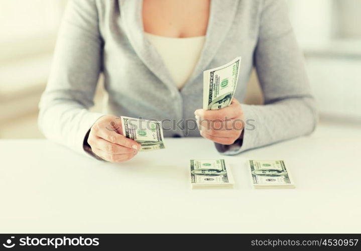 business, finance, saving, banking and people concept - close up of woman hands counting us dollar money