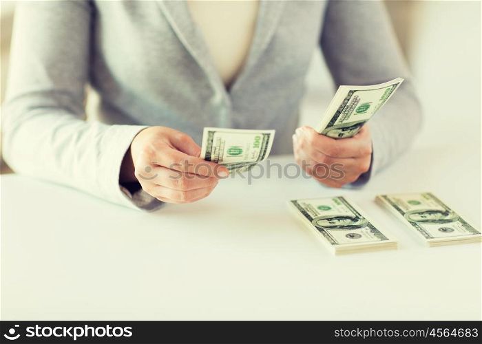 business, finance, saving, banking and people concept - close up of woman hands counting us dollar money