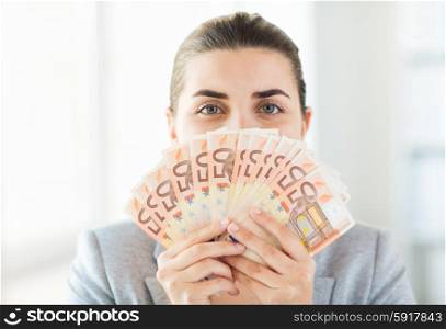 business, finance, saving, banking and people concept - close up of woman hiding her face behind euro money fan