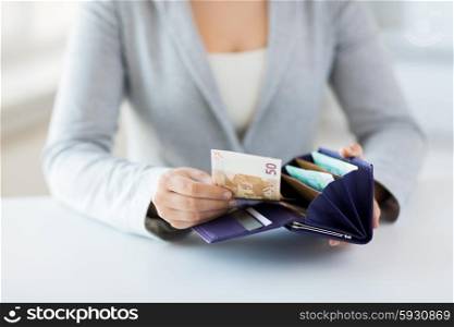 business, finance, saving, banking and people concept - close up of woman hands with wallet and euro money