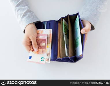 business, finance, saving, banking and people concept - close up of woman hands with wallet and euro money