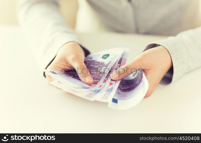 business, finance, saving, banking and people concept - close up of woman hands counting euro money