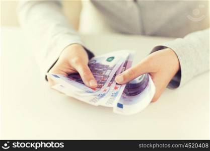 business, finance, saving, banking and people concept - close up of woman hands counting euro money