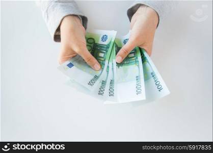 business, finance, saving, banking and people concept - close up of woman hands counting euro money