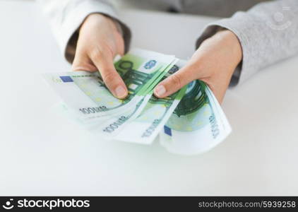 business, finance, saving, banking and people concept - close up of woman hands counting euro money