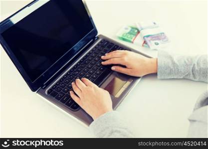 business, finance, saving, technology and people concept - close up of woman hands with laptop computer and euro money