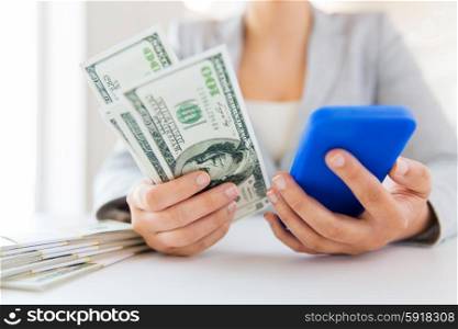 business, finance, saving, technology and people concept - close up of woman hands with smartphone and us dollar money