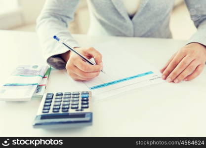 business, finance, tax and people concept - close up of woman hands counting euro money with calculator and tax report form. close up of hands counting money with calculator