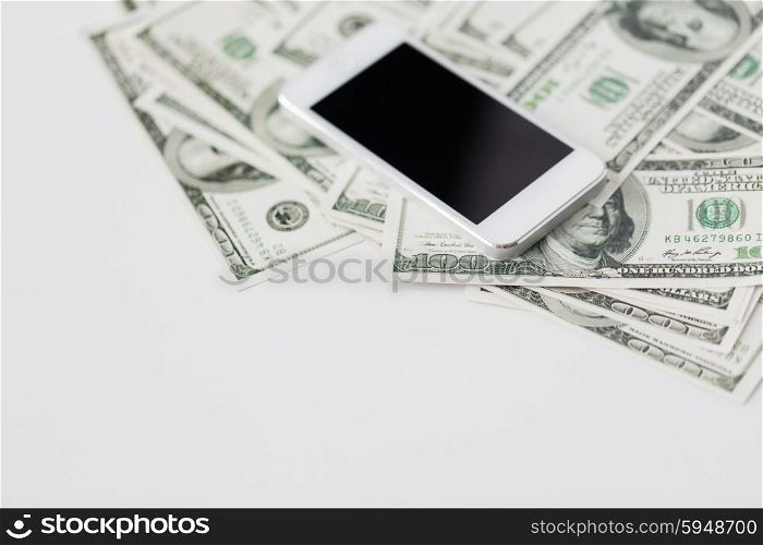 business, finance, technology and e-commerce concept - close up of smartphone with black blank screen and dollar money