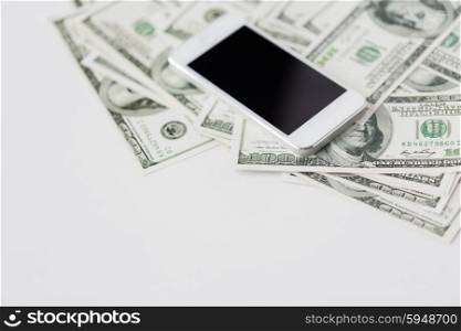 business, finance, technology and e-commerce concept - close up of smartphone with black blank screen and dollar money