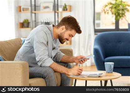 business, finances, accounting and people concept - man with money and calculator filling papers at home. man with money and calculator filling papers