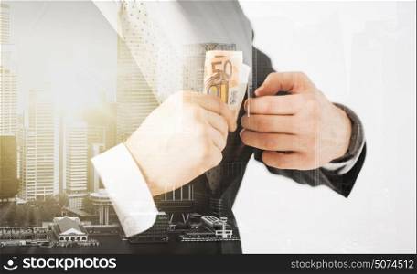 business, finances and people concept - close up of businessman with euro money over city with double exposure. close up of businessman with euro money