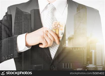 business, finances and people concept - close up of businessman with euro money over city with double exposure. close up of businessman with euro money