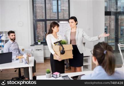 business, firing and job loss concept - executive and sad fired asian female office worker holding box of his personal stuff. executive seeing off fired female office worker