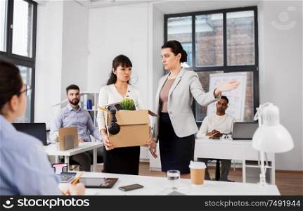 business, firing and job loss concept - executive and sad fired asian female office worker holding box of his personal stuff. executive seeing off fired female office worker