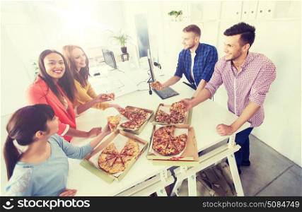 business, food, lunch and people concept - happy international business team eating pizza in office. happy business team eating pizza in office. happy business team eating pizza in office