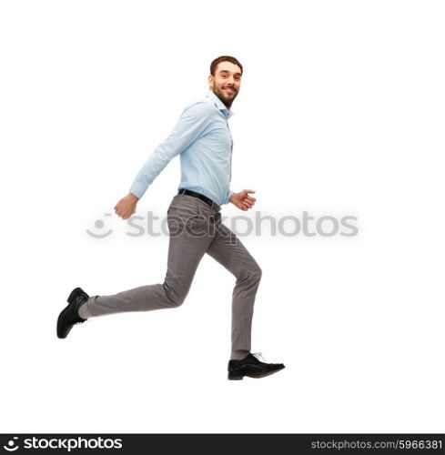 business, freedom, movement and people concept - smiling young man jumping or running away