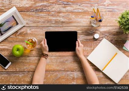 business, freelance and technology concept - woman hands with tablet pc computer and notebook at office table. hands with tablet pc and notebook at office table