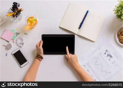 business, freelance and technology concept - woman hands with tablet pc computer and notebook at office table. hands with tablet pc and notebook at office table