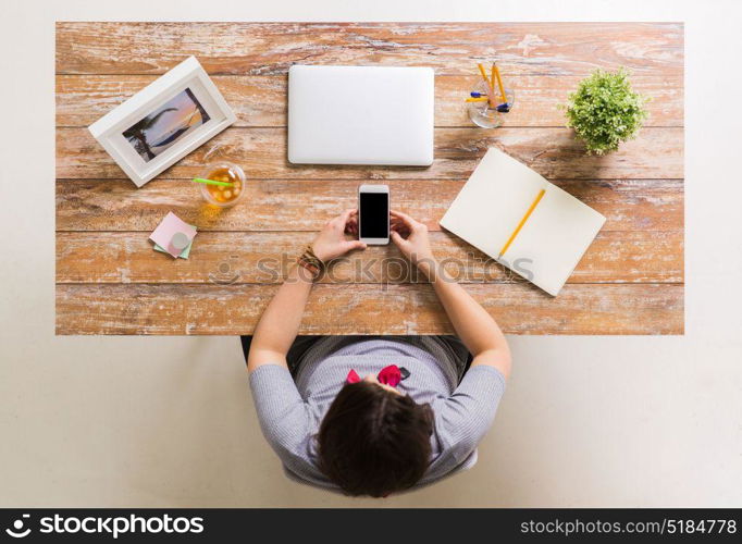 business, freelance and technology concept - woman with smartphone, notebook and laptop computer at wooden office or home table. woman with smartphone and laptop at office table