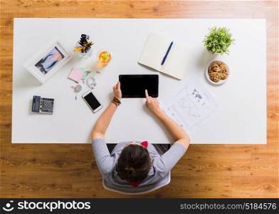 business, freelance and technology concept - woman with tablet pc computer and notebook at office table. woman with tablet pc and notebook at office table