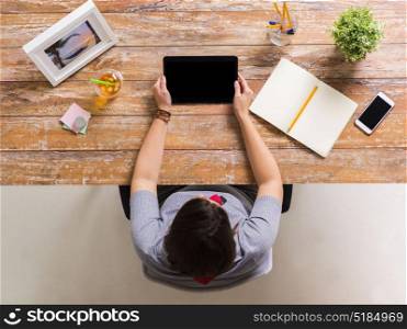 business, freelance and technology concept - woman with tablet pc computer and notebook at office table. woman with tablet pc and notebook at office table