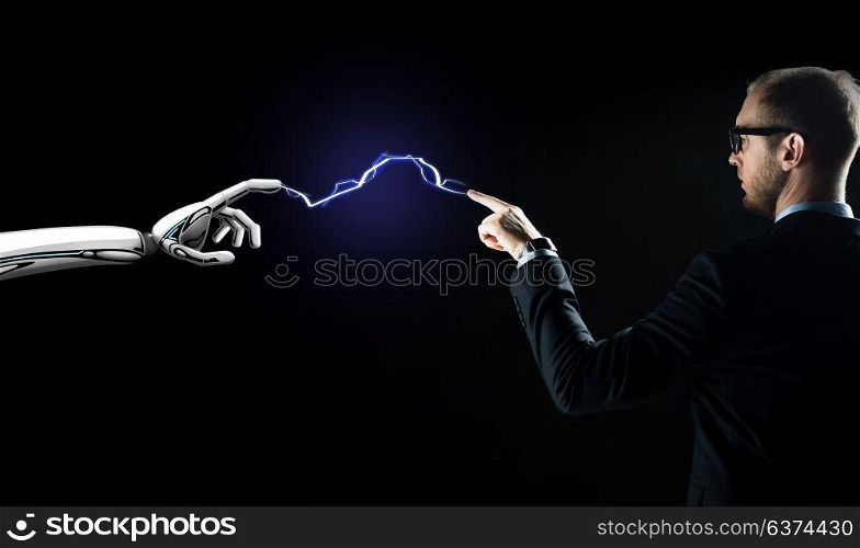 business, future technology and artificial intelligence concept - businessman and robot hand connected by lightning over black background. robot and businessman connected by lightning