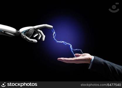 business, future technology and artificial intelligence concept - robot and human hand connected by lightning over black background. robot and human hand connected by lightning. robot and human hand connected by lightning