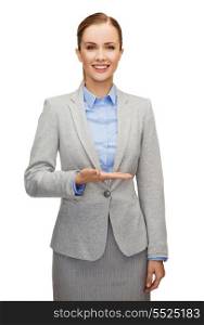 business, future technology and office concept - smiling businesswoman holding something imaginary on palm of her hand