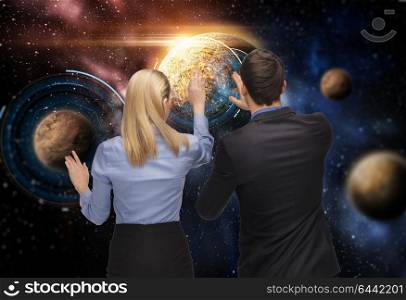 business, future technology and people concept - businessman and businesswoman with planet and hologram over space background. businessman and businesswoman over space