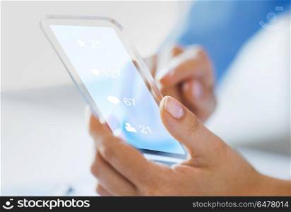 business, future technology and people concept - close up of female hand holding and showing transparent smartphone with social media icons over black background. hand with social media icons on smartphone. hand with social media icons on smartphone