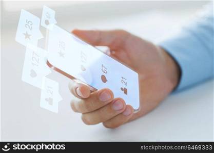 business, future technology and people concept - close up of male hand holding and showing transparent smartphone with social media icons over black background. hand with social media icons on smartphone